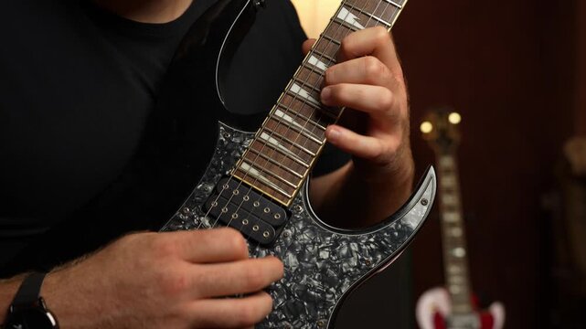 Young guy with ginger beard playing electrical guitar. Strumming and tapping and string picking.