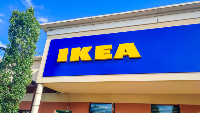 Le Mans, France - July 26, 2026: IKEA Compact store exterior with blue signage and yellow letters, green trees in foreground under clear blue sky