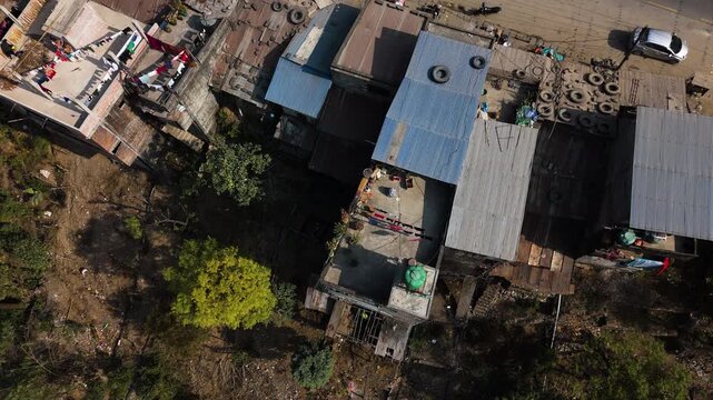 High angle drone shot rising in front of traditional houses in Nepal, sunny day