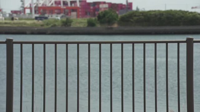 港湾フェンス越しに見るコンテナ群と作業クレーンの風景 4K