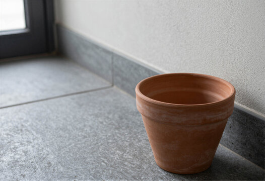 Empty terracotta flower pot on a stone floor