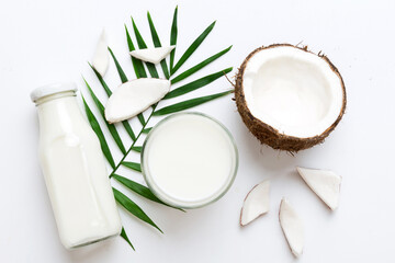 coconut products on white wooden table background. Dairy free milk substitute drink, Flat lay...