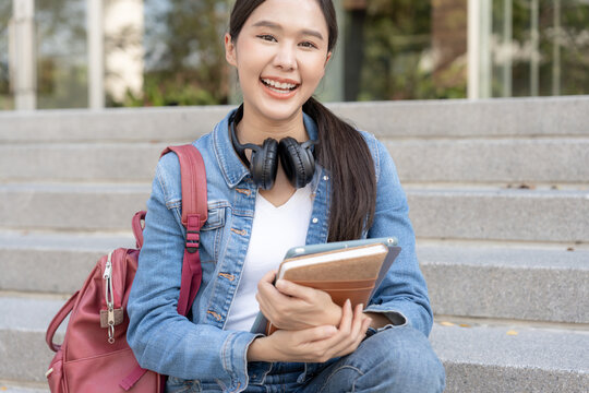 Beautiful student asian woman with backpack and books. Smile girl happy carrying and note on book in college campus. Portrait female on international Asia University. Education