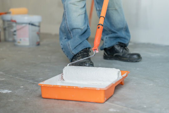 painter man, brush in hand dip on paint for restore and paint the wall, indoor the building site of a house, wall during painting, renovation, painting, contractor, Architect, construction worker