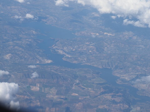 High altitude aerial view of a large river winding through a mountainous landscape