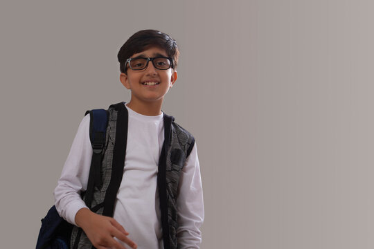 Portrait of a happy young boy holding a backpack (Children) 