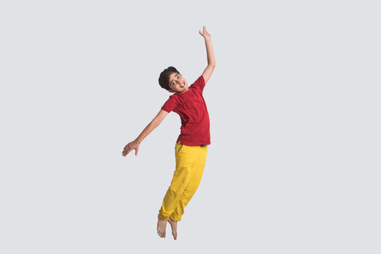 Portrait of a happy young boy jumping in the air in excitement (Children)  
