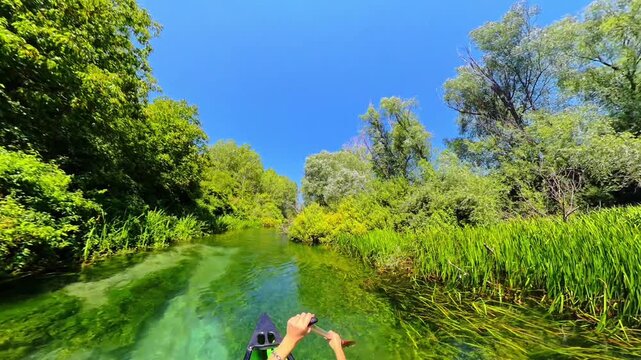 Woman Canoeing on the Crystal Clear Turquoise Water of Tirino River Surrounded by Lush Green Forest, Abruzzo, Italy