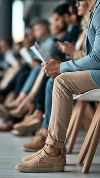 Candidates in Waiting: A group of diverse job seekers are seated in a waiting area, holding documents and appearing expectant, ready for their interviews or to begin a new opportunity.