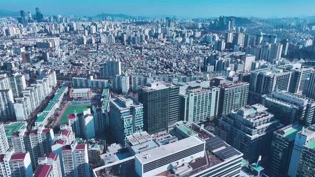An aerial view of a dense urban neighborhood in Seoul showing rooftops, roads, and buildings from a high vantage point.