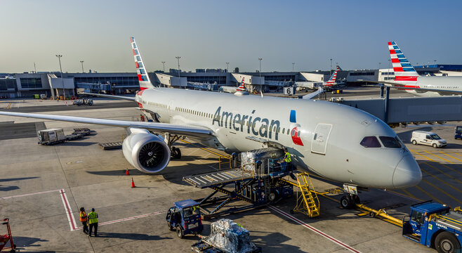 Queens, New York, USA &ndash; July 23, 2023: Ground crew workers load baggage and catering supplies onto an American Airlines passenger jet at JFK International Airport Terminal 8.