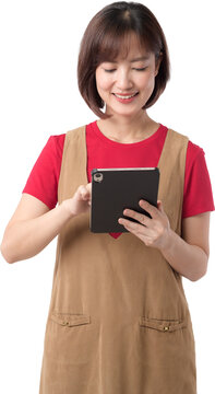 Happy smiling young asian woman holding tablet device wearing apron over red shirt isolated on white studio background
