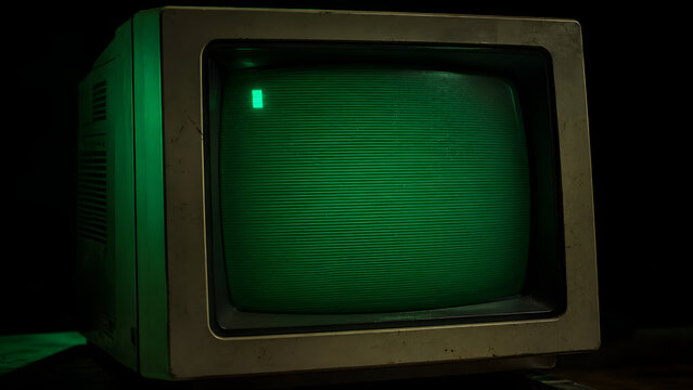 Vintage computer monitor with bright green screen and cursor