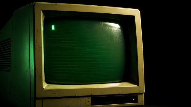 Vintage computer monitor with bright green screen and cursor