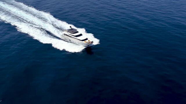 Aerial view of an modern luxury yacht cruising over calm ocean with high speed