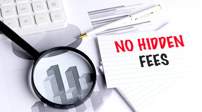 No hidden fees concept with magnifying glass, calculator, pen and financial charts on office desk background