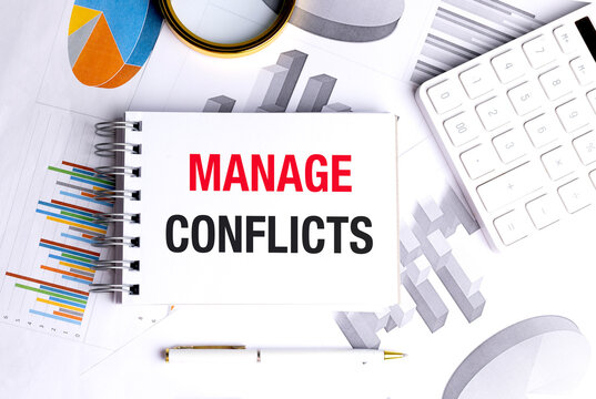 Manage conflicts concept with notebook, calculator, charts and office supplies on workplace desk background
