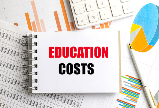 Education costs text on spiral notebook with calculator, charts and financial documents