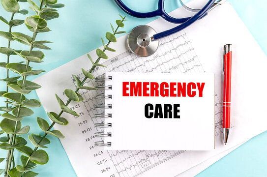 Emergency care text on spiral notebook with stethoscope, medical report and red pen on blue background