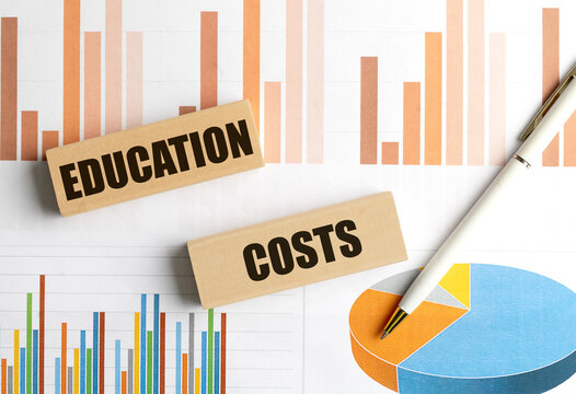 Education costs concept with wooden blocks, financial charts and pen on business documents