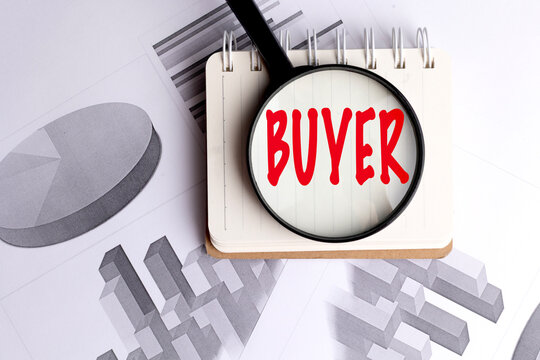 Buyer concept with magnifying glass, notebook and financial charts on office desk background