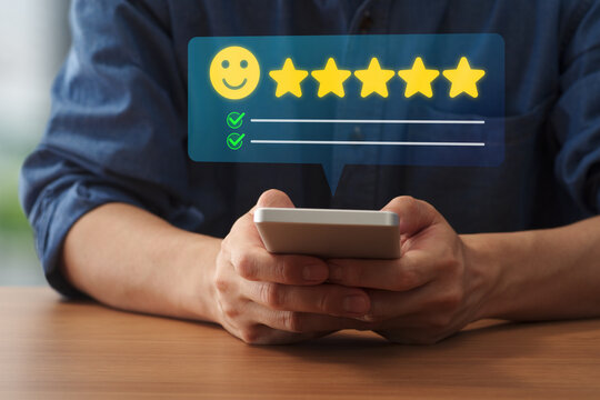 Customer satisfaction review. Customer posting five-star rating and positive user experience feedback through mobile app on smartphone.