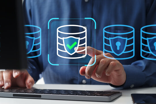 Access control system protecting databases and servers. Cybersecurity platform managing secure access. Zero trust security. Businessman tapping database icon. Computer keyboard and monitor on desk.