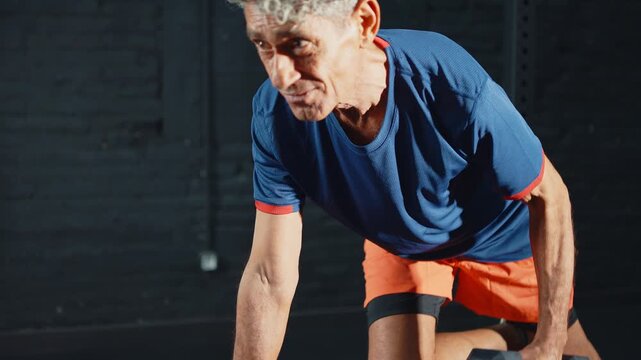 Elderly man with grey hair strengthening his back muscles with a dumbbell row on a bench, a dedicated fitness routine to maintain his health, strength, and vitality in his golden years
