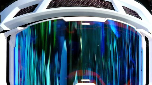 a motocross goggle lens displaying a vibrant, mirrored iridescent finish