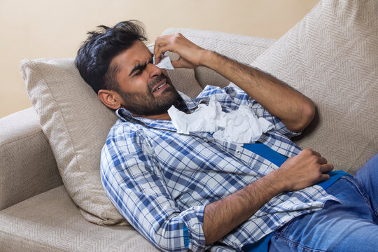 Man crying on the sofa with tissues 