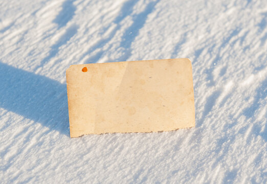 Blank vintage card offers copyspace. Snow background creates seasonal mood