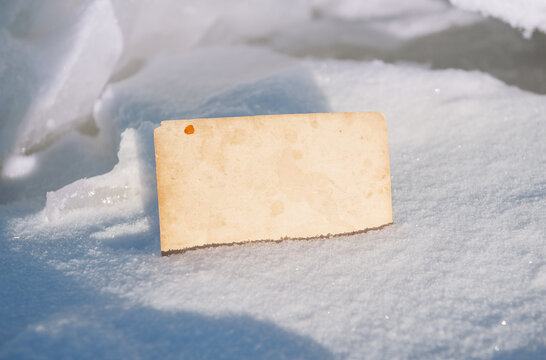 Blank vintage card offers copyspace. Snow background creates seasonal mood