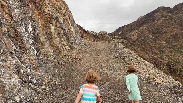Children hiking along a rocky path up the mountain