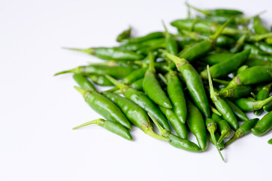Close-up heap of fresh green bird's eye chilies or cabe rawit hijau as spicy culinary ingredients