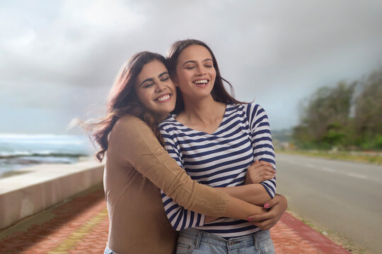 Woman holding her friend tightly standing outdoors