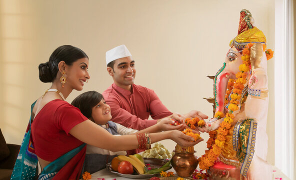 Family offering flowers to Ganpati Idol on Ganesh Chaturthi