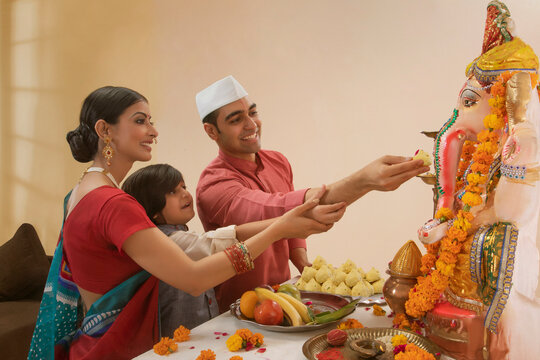 Family offering modak to Ganpati Idol on Ganesh Chaturthi