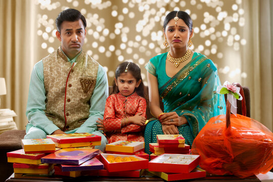 upset family sitting on a sofa with presents on diwali