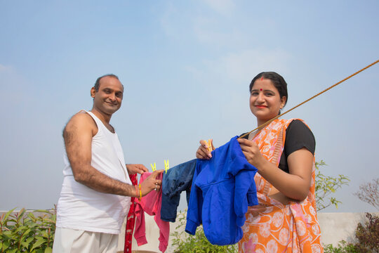 indian Couple drying clothes on clothesline