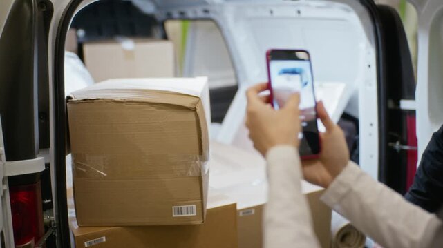 Male delivery worker pointing at damaged cardboard box in van while female customer taking photo with smartphone. Perfect for logistics, insurance claims, and ecommerce shipping dispute concepts