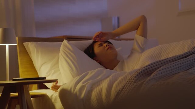 夜ベッドで眠る体調不良の女性