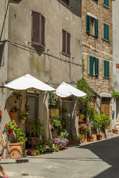 Pitigliano street with charming flowers and rustic architecture