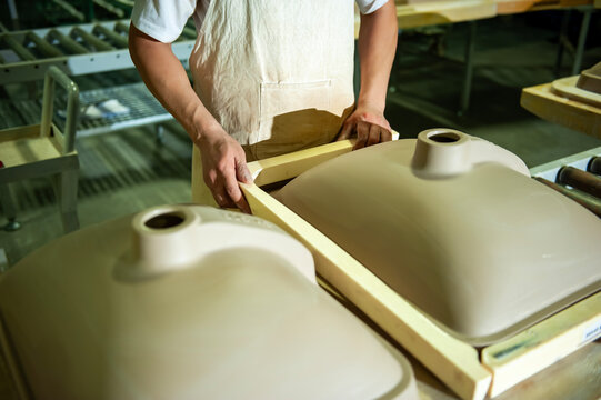 Workers work on the assembly line in the sink production workshop.
