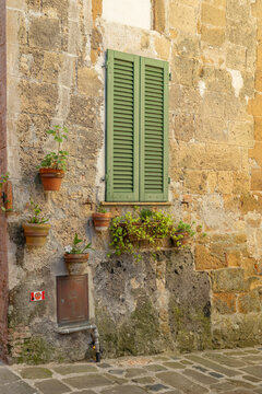 Stone wall with green window shutters, Sorano, Tuscany, Italy