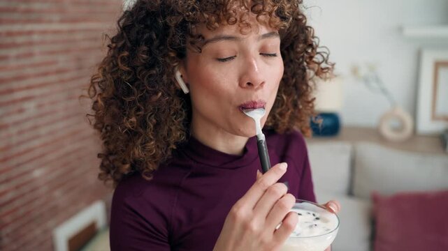 Video of pretty woman eating healthy yogurt bowl at home