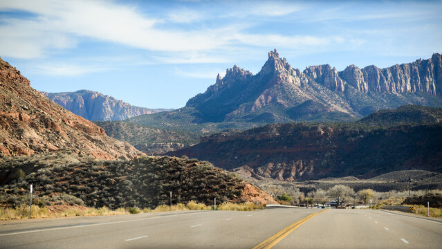 Highway leading towards massive sandstone cliffs in Zion National Park, southern Utah. USA.