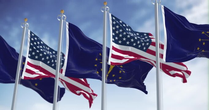 Indiana state flags waving with the national flag of the US on a clear day