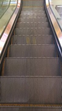 Empty moving escalator steps going down in building