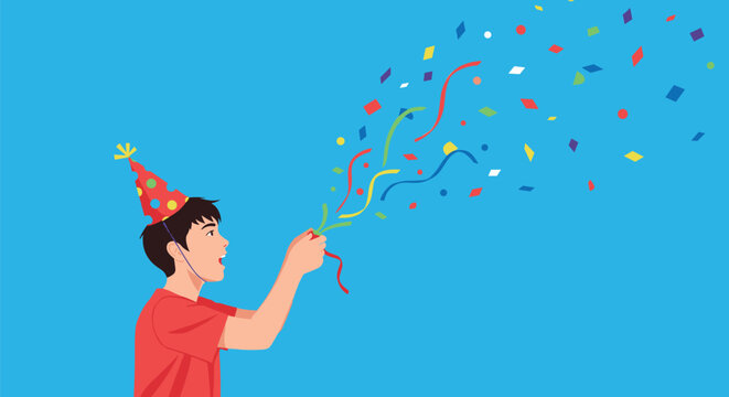Happy young boy wearing a party hat and throwing colorful confetti to celebrate a birthday or holiday event.