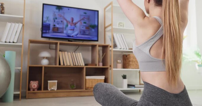 Woman yoga at home with online fitness television. She follows an instructor onscreen, in meditation for mindfulness, focusing on balance and a calm workout. Calm mindful wellness home concept